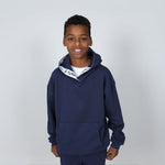Boy aged 11 wearing a navy blue regenerative cotton hoodie with a 'Svante' white logo on a grey background