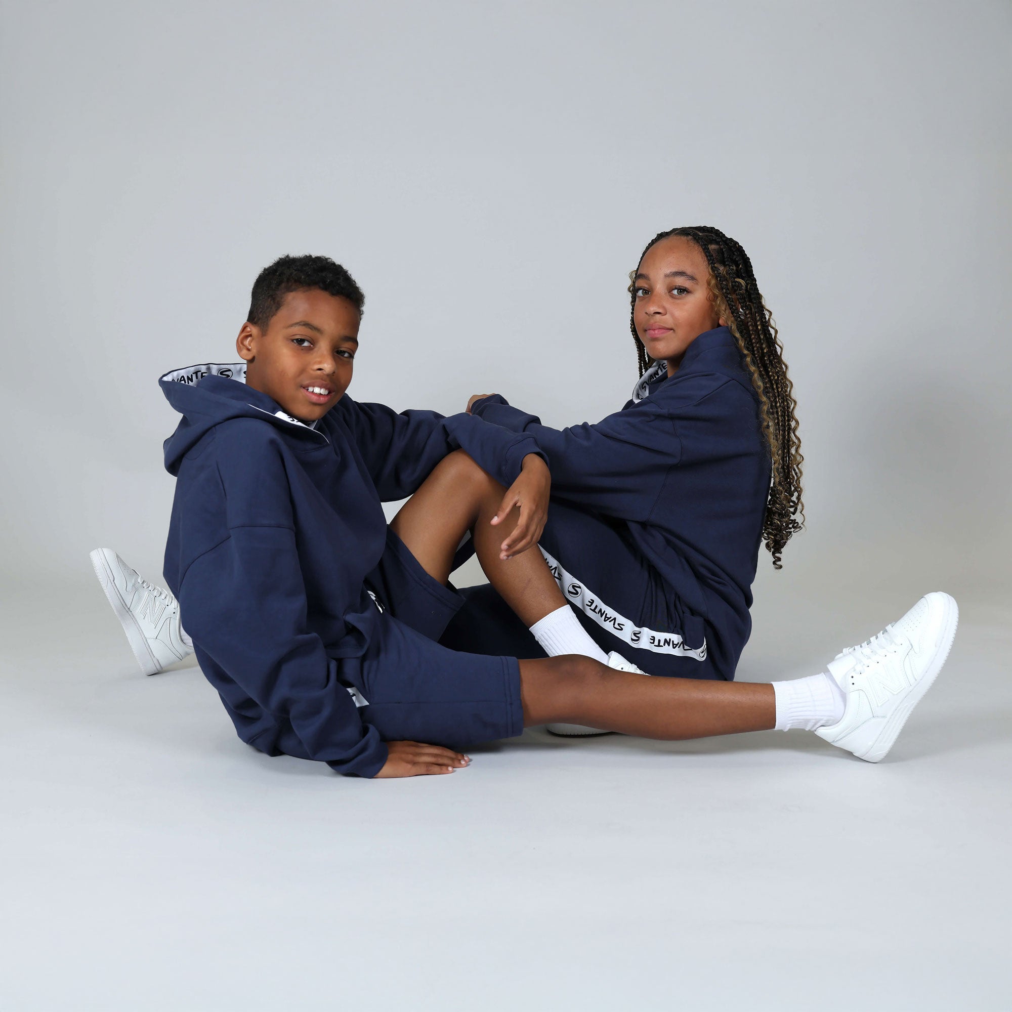 Black girl and boy wearing organic cotton and regenerative cotton tracksuit hoody, joggers and shorts. 