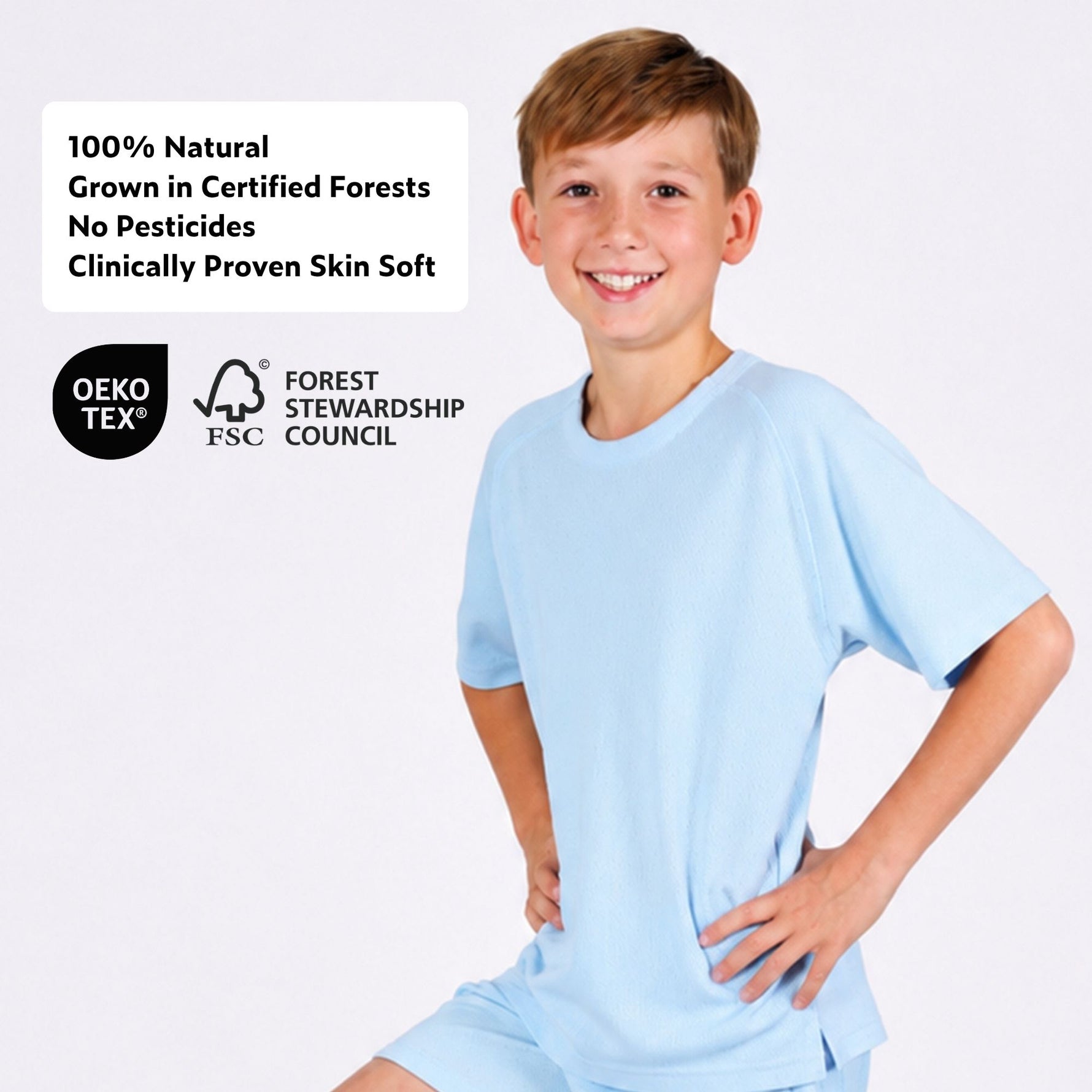 Boy wearing a natural material light blue sports T-shirt with certification logos on a white background