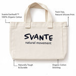 An off-white Svante organic cotton canvas tote bag with black printed text reading 'SVANTE natural movement' on the front, shown on a white background with callout lines and text describing material and print features.