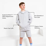 Boy wearing a Svante grey organic cotton hoodie and grey organic cotton jersey shorts with plain white studio background.  Background with text callouts highlighting product features such as Svante Earthknit™ cotton, zero polyester or toxic dyes, plastic-free cuffs, and organic cotton stitching. 
