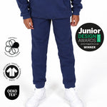 Boy wearing Svante navy blue organic cotton sweatpants and a matching navy sweatshirt, paired with white sneakers, shown from the waist down against a plain white studio background. 