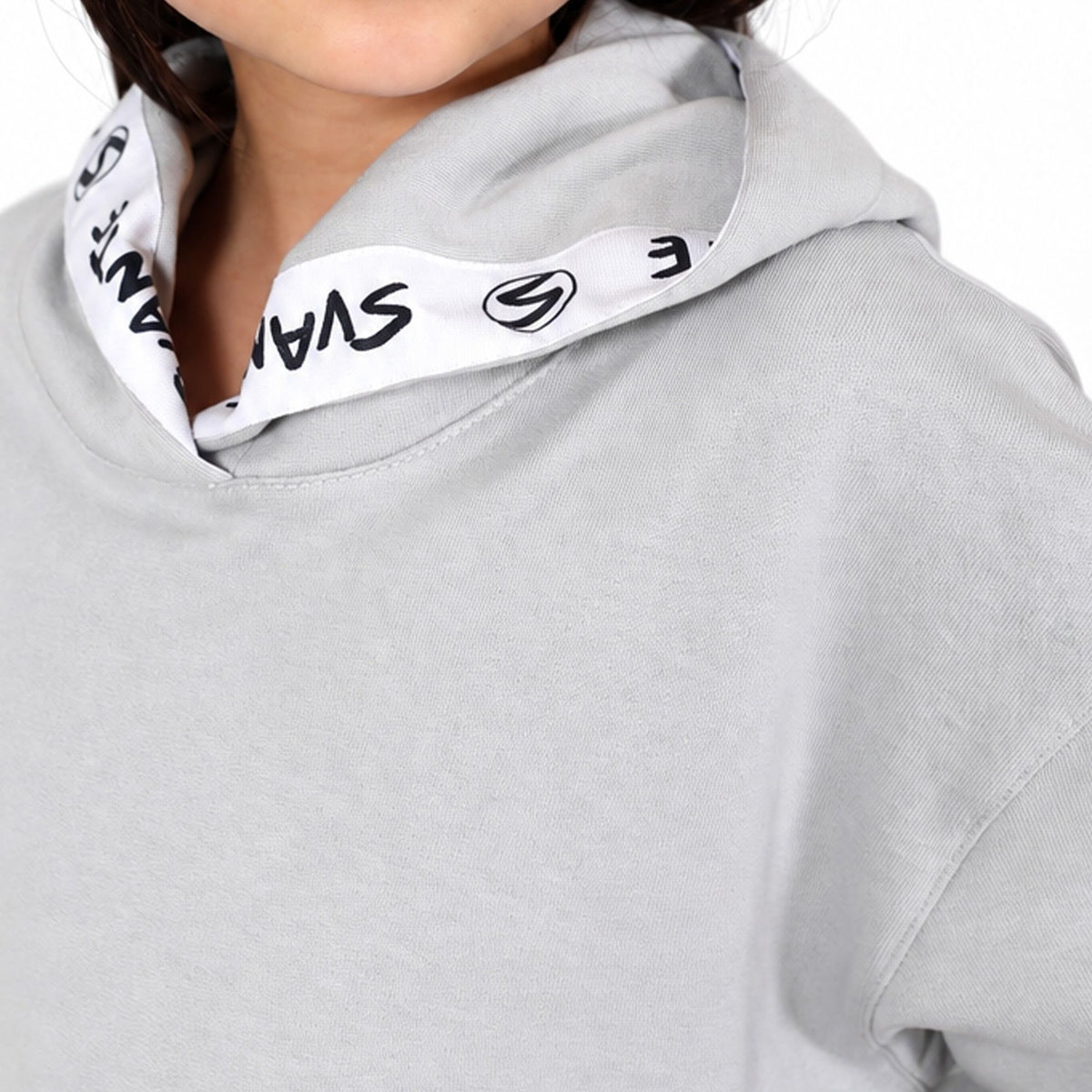 Close-up of a person wearing a svante organic cotton light grey hoodie with a white inner hood lining printed with black stylised lettering and logos. 