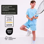 Boy in blue natural material polyester free tennis outfit holding a racket with certification logos on a white background