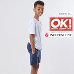 Boy wearing a regenerative cotton white t-shirt and blue organic jersey shorts on a white background with OK! and Independent logos. 