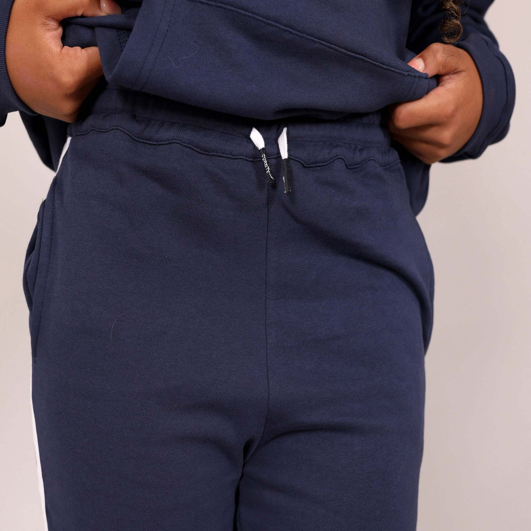 Close up of navy blue joggers waist band and 'Svante' branded organic cotton draw strings with a plain background